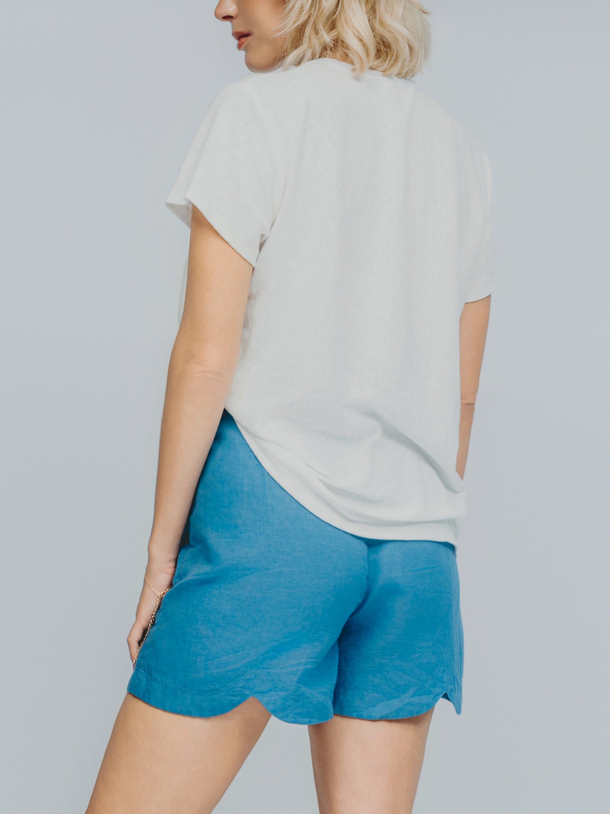 Chroma T-shirt back view, styled with blue shorts - luxury resort wear piece