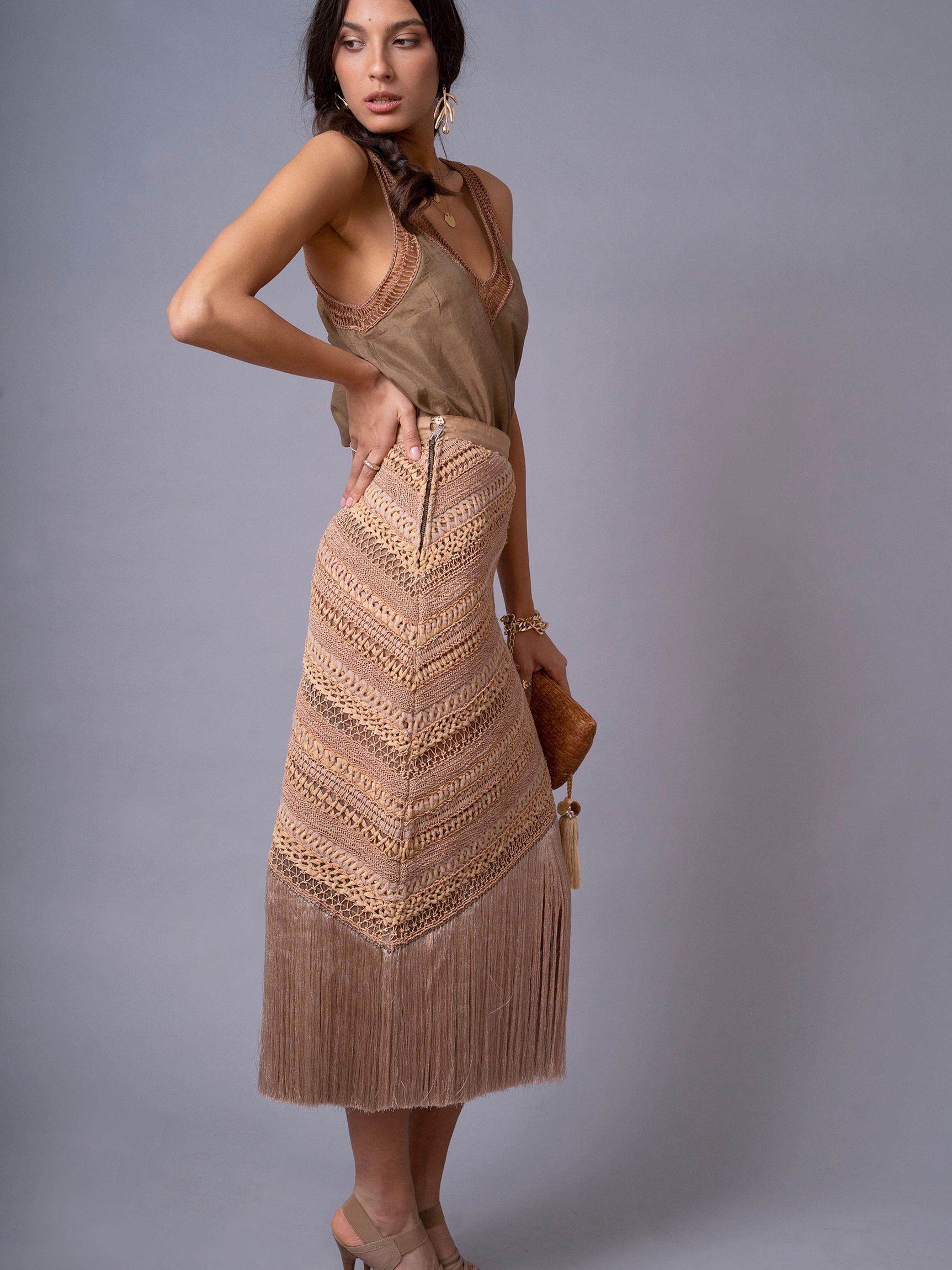 Side profile of model wearing OCHRIDIA Fringe Skirt highlighting silhouette and fringe movement
