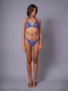 A model wearing blue low rise briefs with a polka dot pattern from the Hidden Heritage collection.