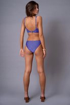 A model wearing blue low rise briefs with a polka dot pattern from the Hidden Heritage collection.